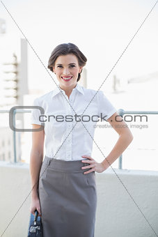 Smiling stylish brown haired businesswoman posing looking at camera