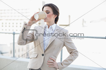 Peaceful stylish brown haired businesswoman drinking coffee