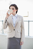 Calm stylish brown haired businesswoman drinking coffee