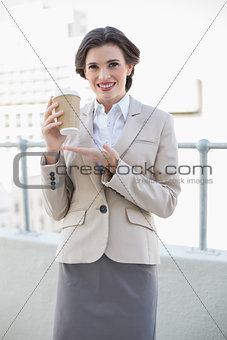 Delighted stylish brown haired businesswoman showing her coffee