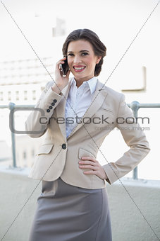 Cheerful stylish brown haired businesswoman calling with her mobile phone