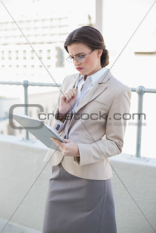 Troubled stylish brown haired businesswoman looking at a report