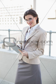 Pleased stylish brown haired businesswoman taking notes