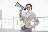 Charming stylish brown haired businesswoman holding a megaphone