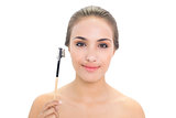 Content young brunette woman holding eyebrow brush