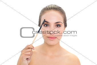 Content brunette woman using eyebrow brush