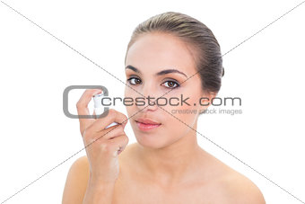 Young brunette woman holding an inhaler