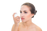 Upset young brunette woman holding an inhaler
