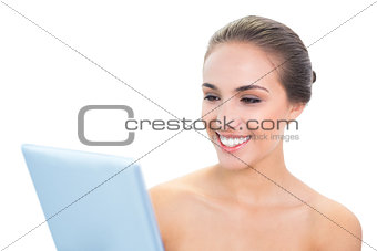Cheerful brunette woman holding a tablet