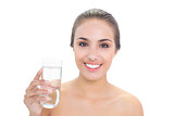 Smiling brunette woman holding a glass of water