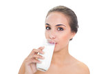 Content brunette woman drinking a glass of milk