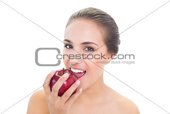 Content young brunette woman biting in a red apple