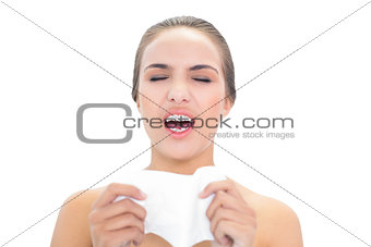Lovely young brunette woman sneezing