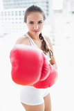Sporty brunette boxing with red gloves