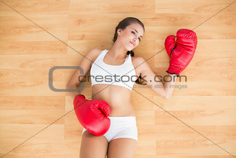 Sporty brunette wearing red boxing gloves
