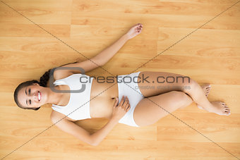 Happy sporty brunette lying down
