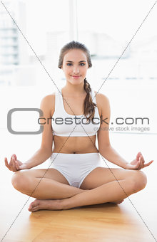 Smiling relaxed brunette meditating