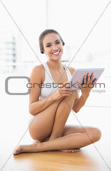 Smiling brunette woman using a tablet