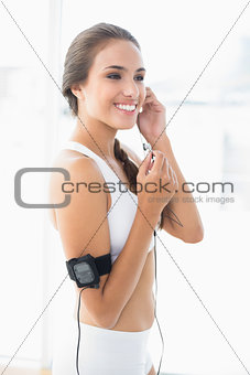 Cheerful sporty brunette listening to music