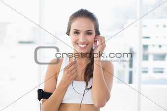 Happy sporty brunette listening to music