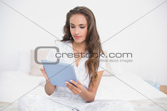 Content attractive brunette using a tablet