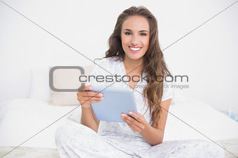 Happy attractive brunette using a tablet