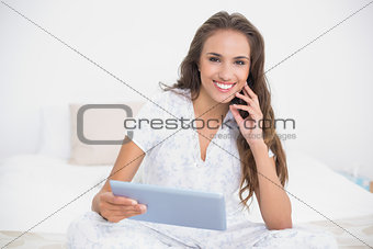 Smiling attractive brunette holding a tablet