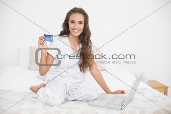 Content attractive brunette holding credit card