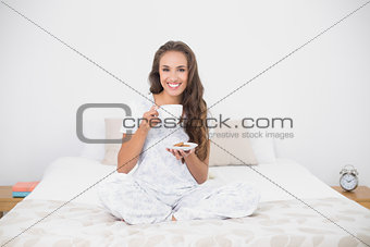 Smiling attractive brunette holding a cup