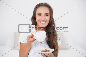 Cheerful attractive brunette holding a cup