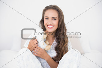 Smiling attractive brunette holding a soft toy