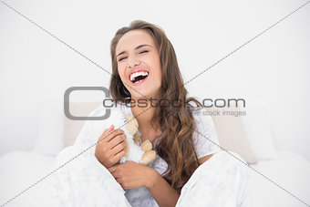 Laughing attractive brunette holding a soft toy