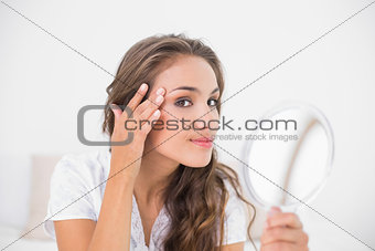 Smiling attractive woman holding mirror