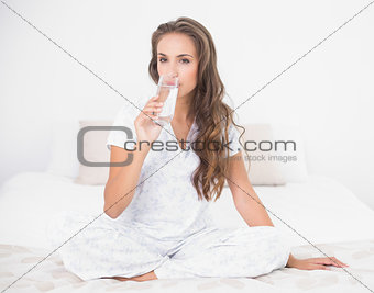Calm pretty brunette drinking a glass of milk