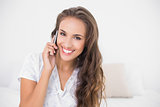 Cheerful pretty brunette holding mobile phone