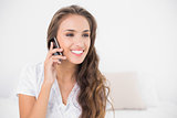 Smiling attractive brunette holding mobile phone