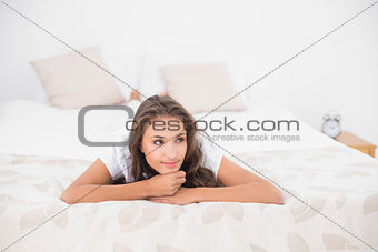 Content pretty brunette lying on bed