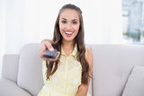 Excited pretty brunette holding remote