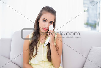 Sad attractive brunette holding a tissue