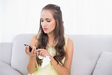Upset young brunette holding mobile phone and tissue