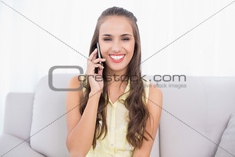 Cheerful pretty brunette using mobile phone