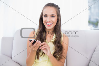 Happy pretty brunette holding smartphone
