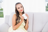 Thoughtful young brunette holding a mug
