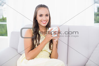 Smiling young brunette holding a mug