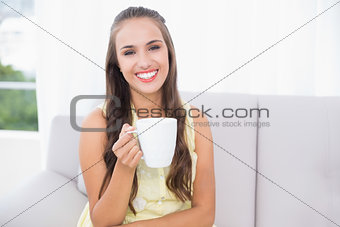 Cheerful young brunette holding a mug