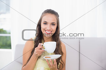 Smiling pretty brunette holding a cup