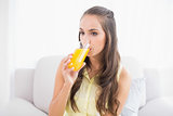 Pretty brunette drinking a glass of orange juice