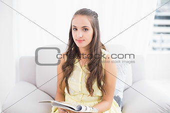 Content young brunette holding magazine