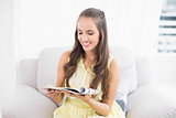 Smiling young brunette reading a magazine