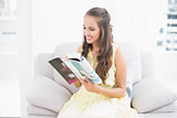 Smiling attractive brunette reading a magazine